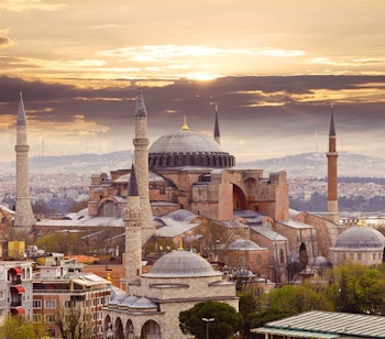 Hagia Sophia moskeen i Istanbul badet i solnedgangens gyldne lys - et imponerende byzantinsk arkitektonisk mesterværk med karakteristisk kuppel og minareter