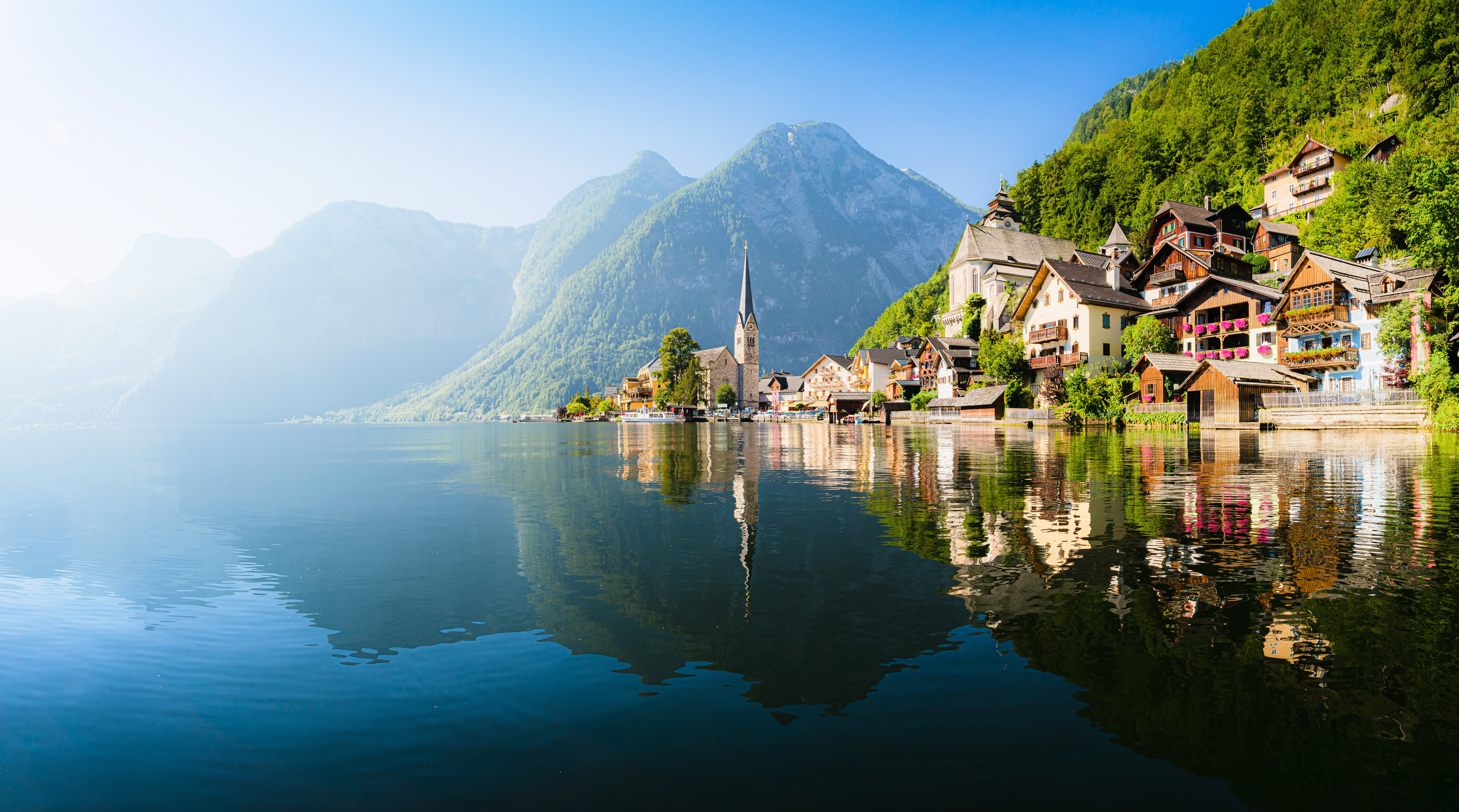 Smukke Hallstatt i Østrig med historiske bygninger og kirke ved alpesø omgivet af bjerge