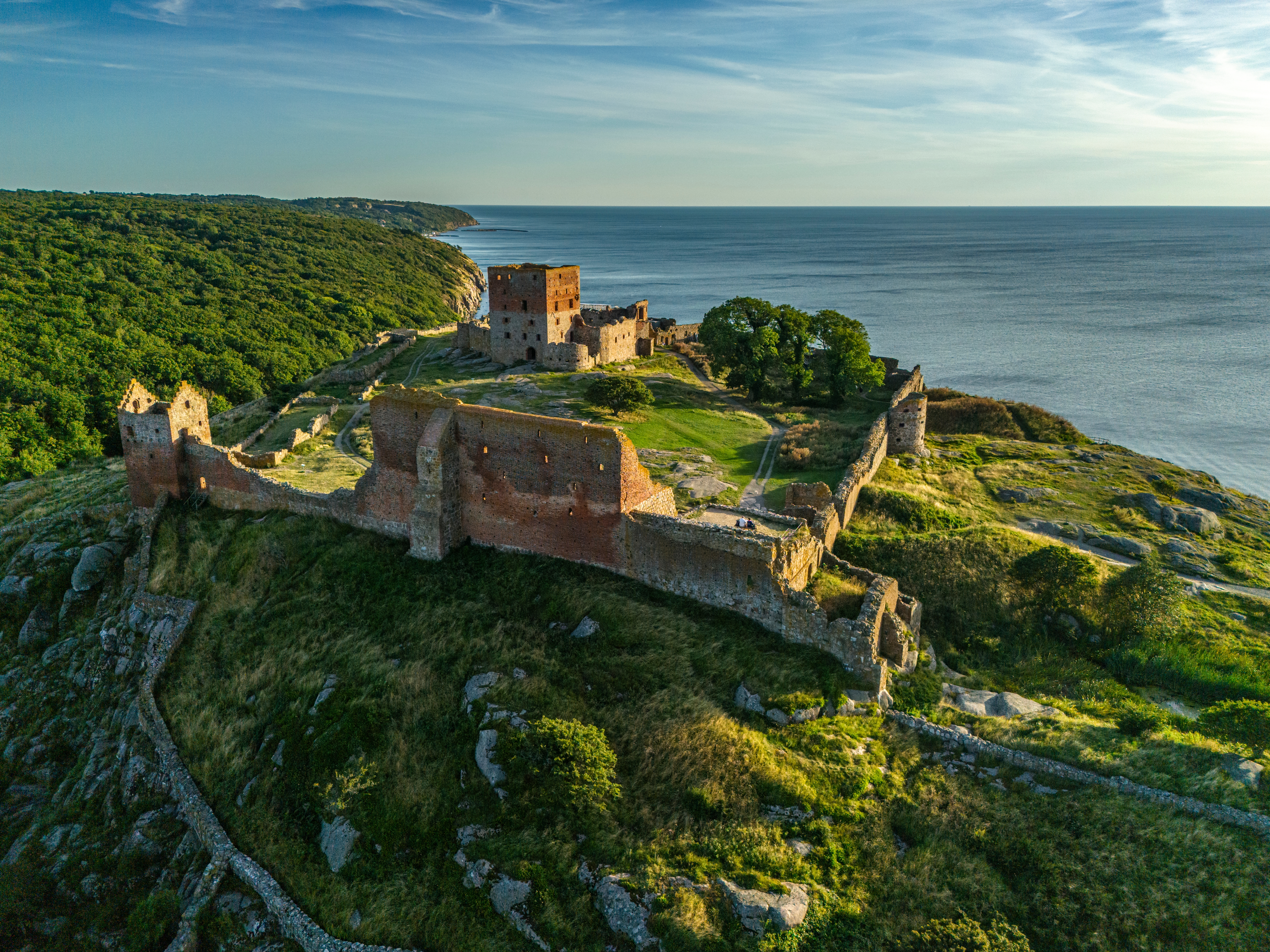 Luftfoto af Hammershus slotsruin på Bornholm med grønne klippekyster og Østersøen i baggrunden