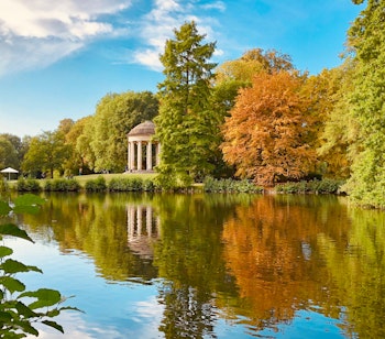 Smuk efterårsudsigt over Hannover med farverige træer der spejler sig i søen under blå himmel