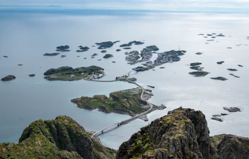 Luftfoto af Henningsvær fiskerleje på Lofoten i Norge, omgivet af roligt blåt hav og forbundet med broer