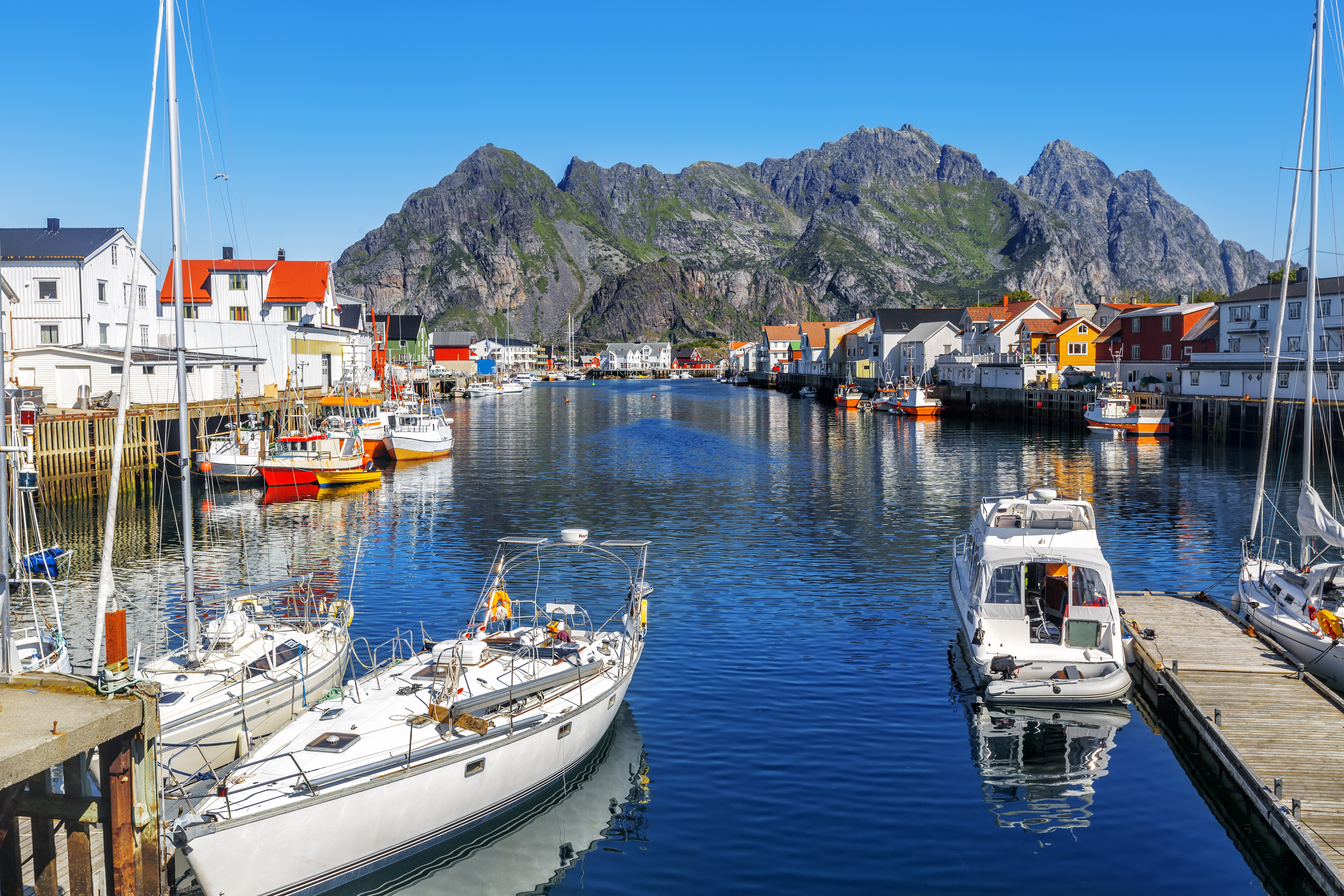 Malerisk norsk fiskerlandsby Henningsvaer på Lofoten med farverige huse og både i havnen