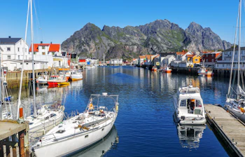 Malerisk norsk fiskerlandsby Henningsvaer på Lofoten med farverige huse og både i havnen