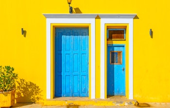 Historisk bygning med traditionel arkitektur på Spetses-øen i Grækenland med hvide mure og gule detaljer tæt på havnen