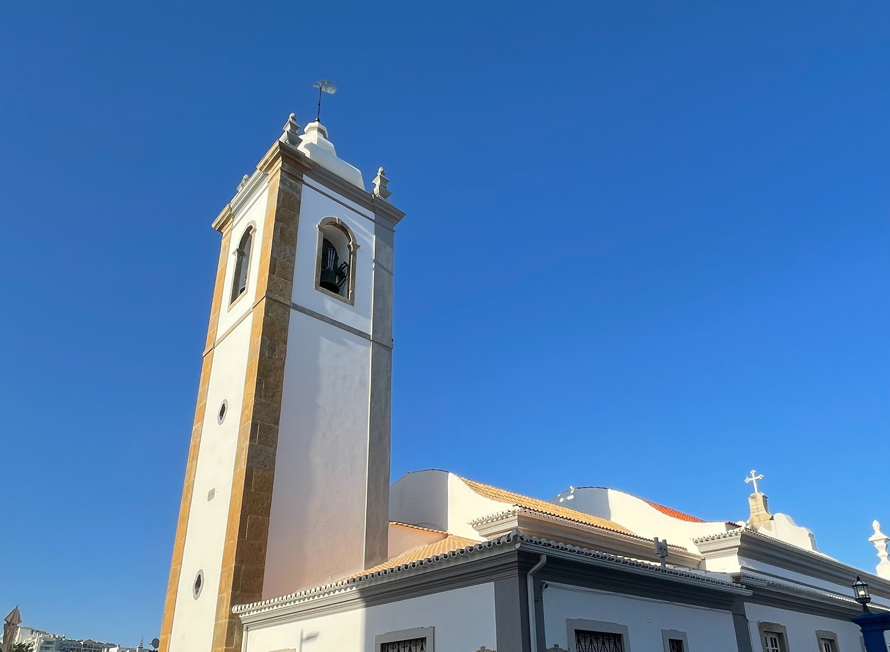 Smuk historisk kirke med klokketårn i Albufeiras gamle bydel, Algarve, Portugal omgivet af traditionel portugisisk arkitektur