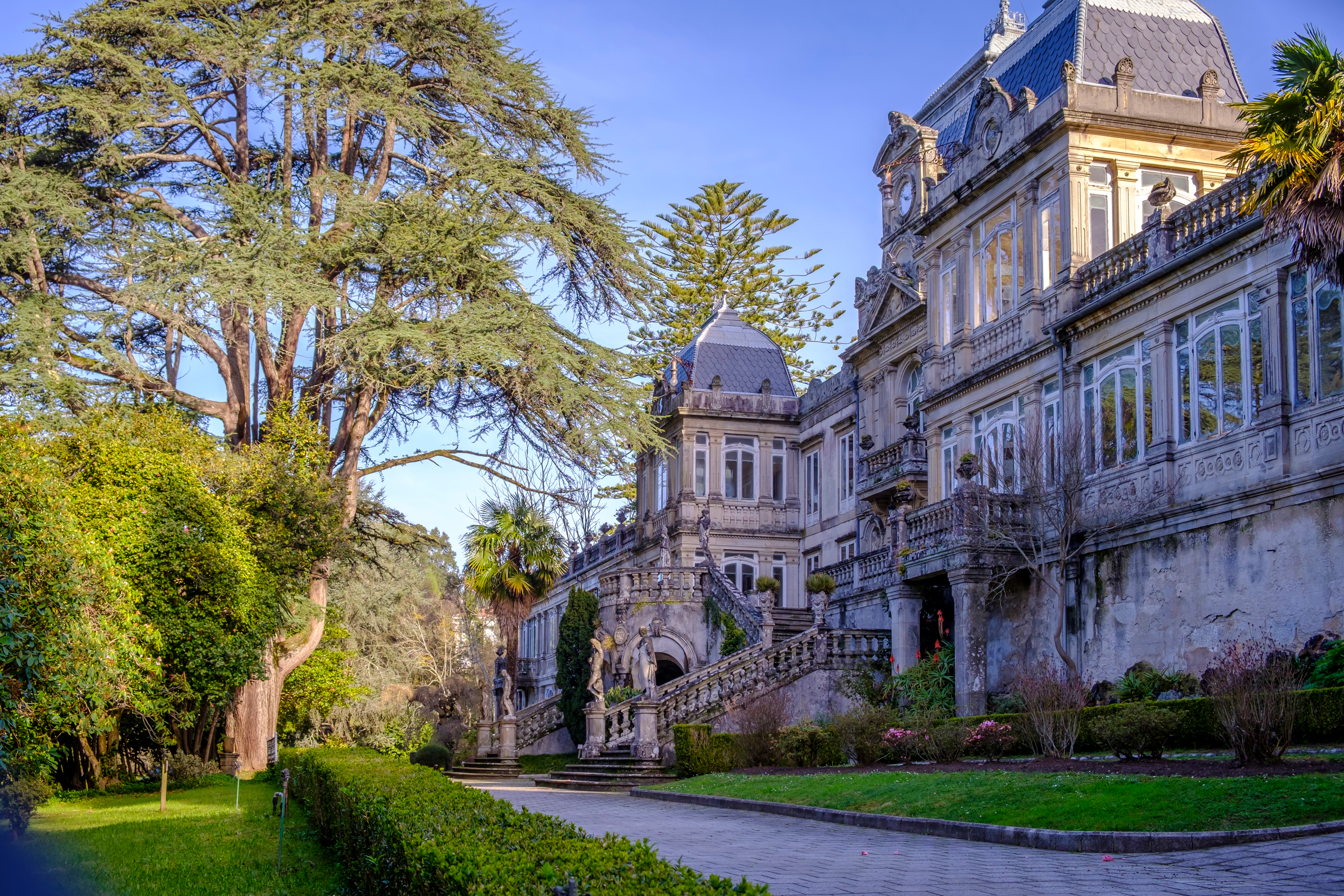 Storslået historisk palads i Pontevedra, Galicien, Spanien, omgivet af grønne haver og høje træer med smuk stentrappe