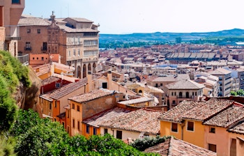 Panoramaudsigt over Zaragozas historiske centrum med teglstenstage og bjerge i baggrunden, destination for solformørkelsesrejse i Spanien