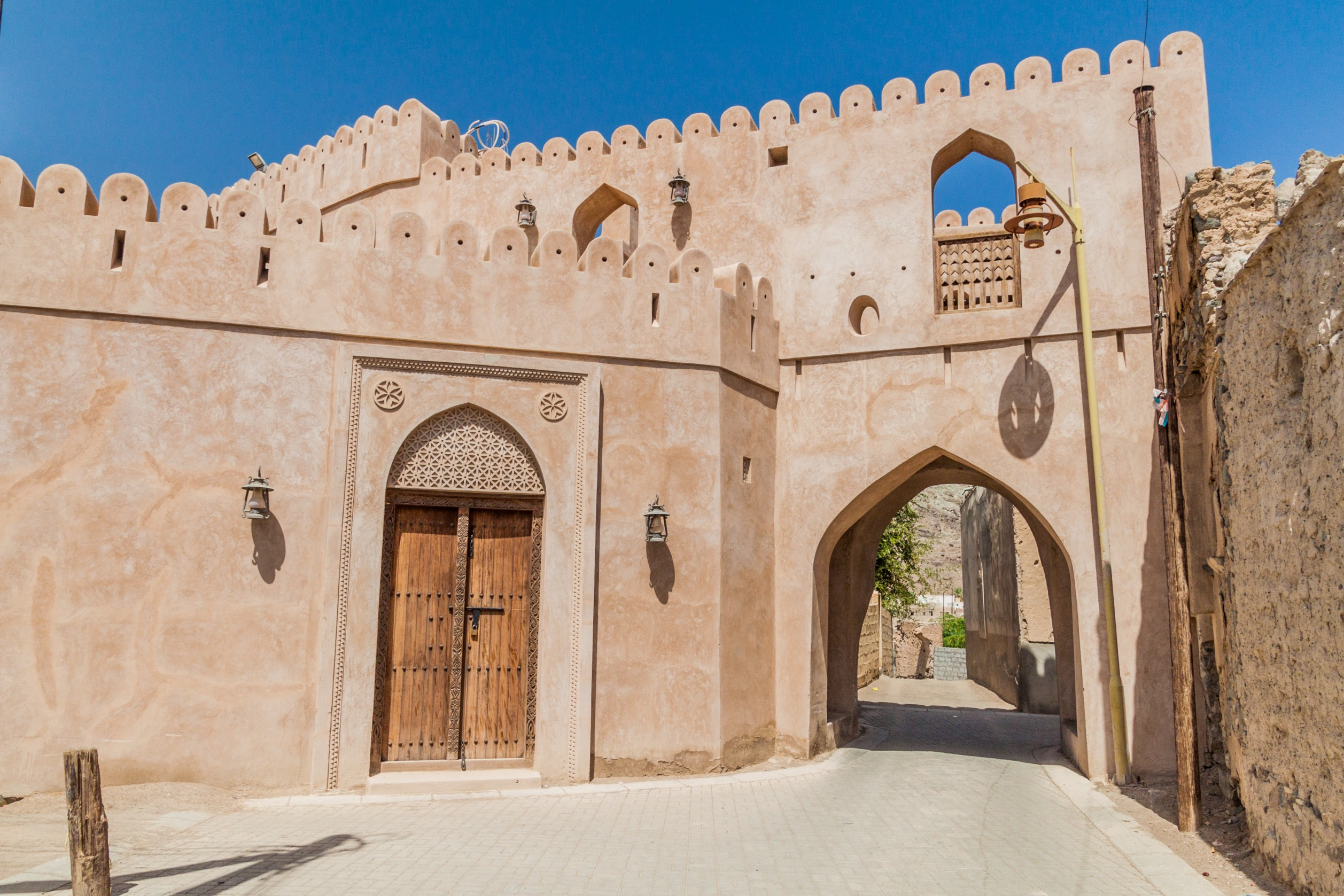 Historisk indgangsport med traditionel arabisk arkitektur i den gamle bydel Ibra i Oman, et fascinerende kulturelt rejsemål