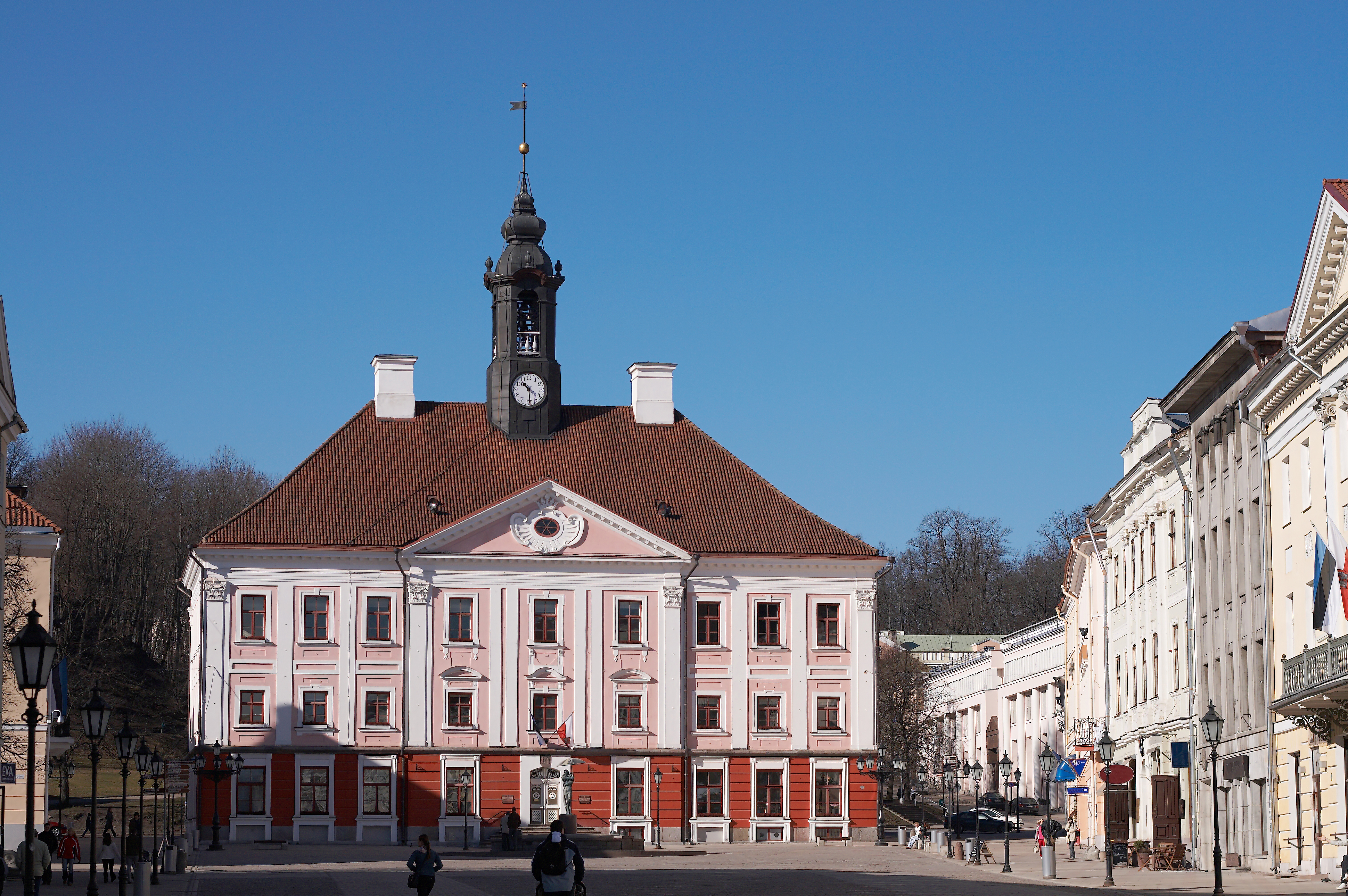 Det historiske røde og hvide rådhus i Tartu, Estland med karakteristisk tårn under klar blå himmel i det tidlige forår