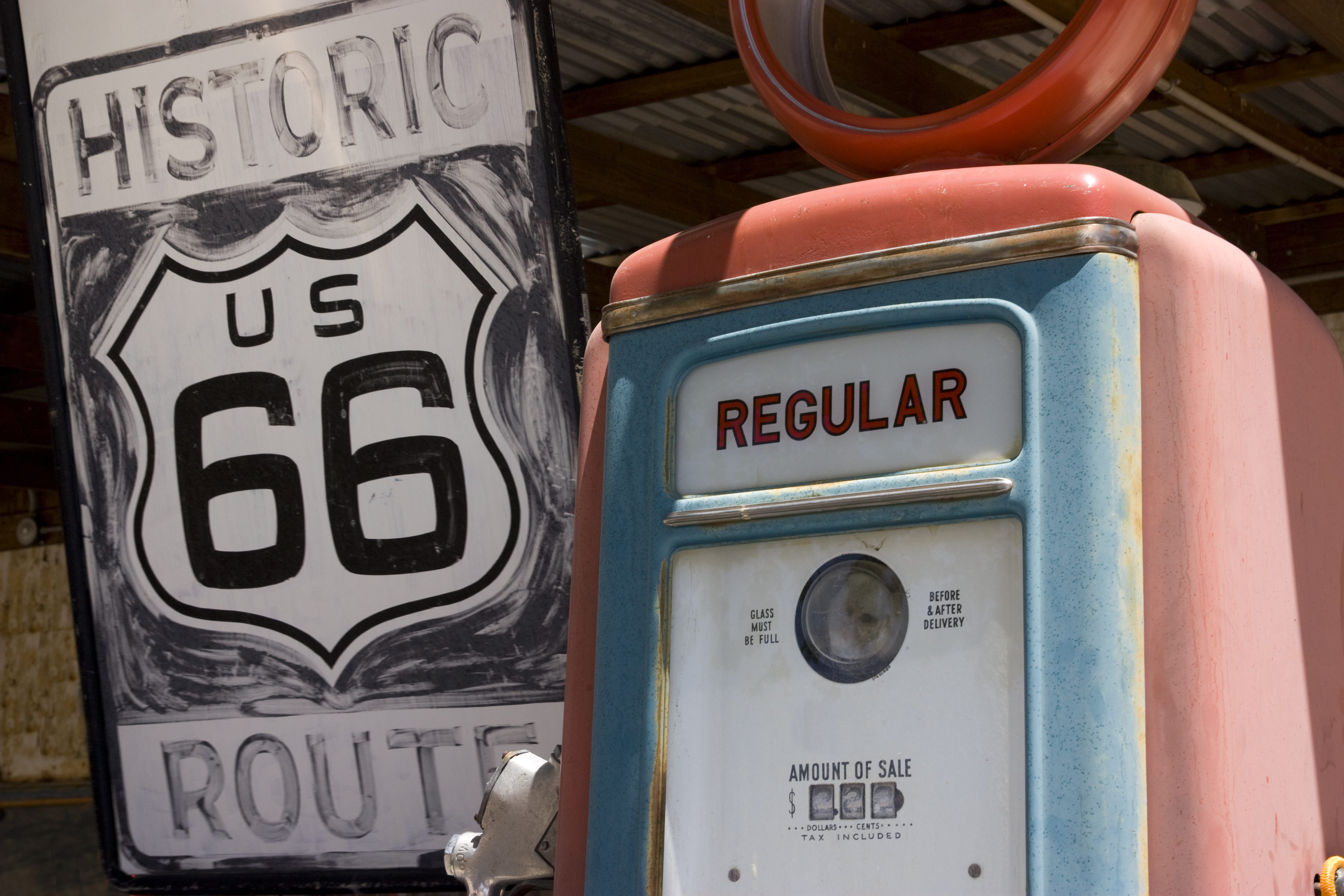 Historisk Route 66 skilt med vintage benzinstation i det amerikanske sydvesten