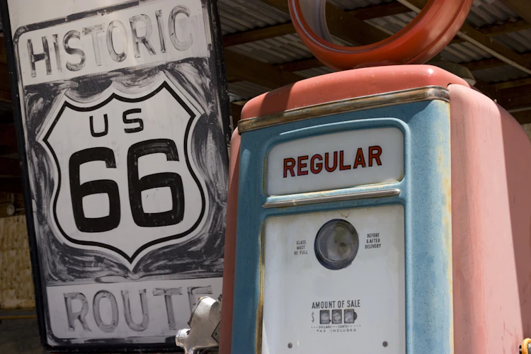 Historisk Route 66 skilt med vintage benzinstation i det amerikanske sydvesten