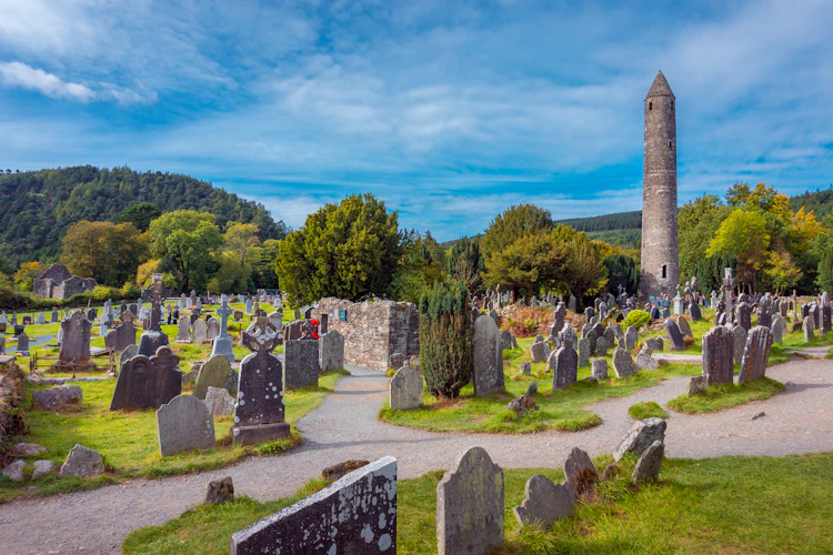 Historisk rundtårn og klosterruiner fra 500-tallet i Glendalough-dalen, County Wicklow - et af Irlands mest betydningsfulde kristne pilgrimssteder
