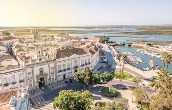Den historiske byport Arco da Vila i Faros gamle bydel med traditionel portugisisk arkitektur og brostensbelagte gader ved Ria Formosa i Algarve
