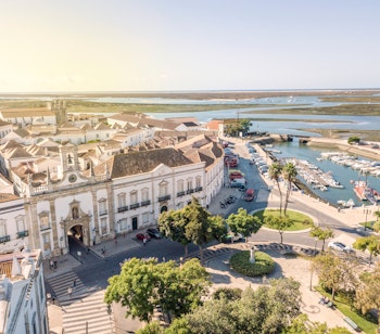 Den historiske byport Arco da Vila i Faros gamle bydel med traditionel portugisisk arkitektur og brostensbelagte gader ved Ria Formosa i Algarve