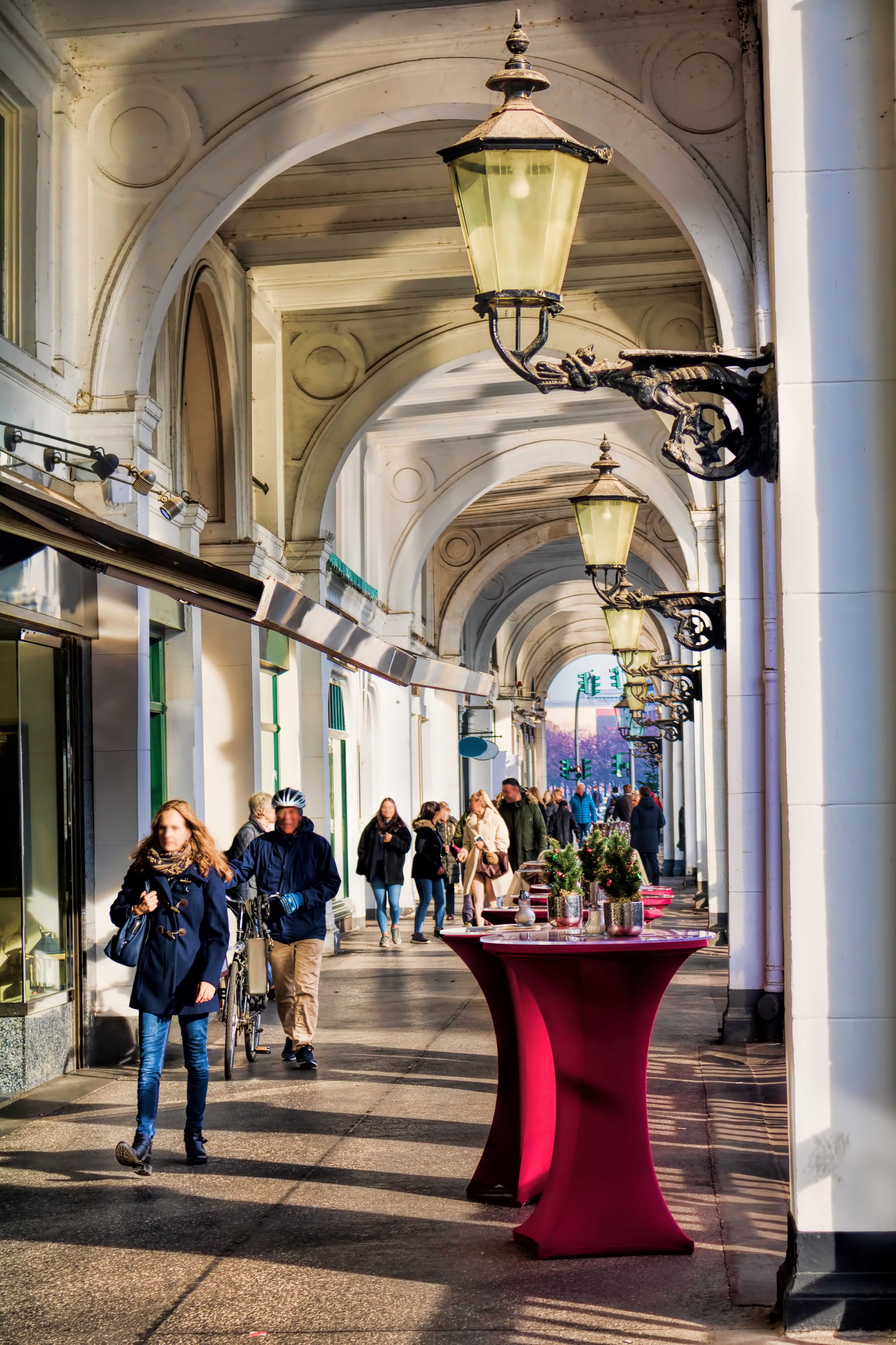 Historiske buegange med elegante søjler og traditionelle lygter i europæisk bycentrum