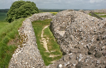 Historiske stenmure og jordvolde fra Old Sarum borgruiner nær Salisbury i England med imponerende voldgrave og forsvarsværker