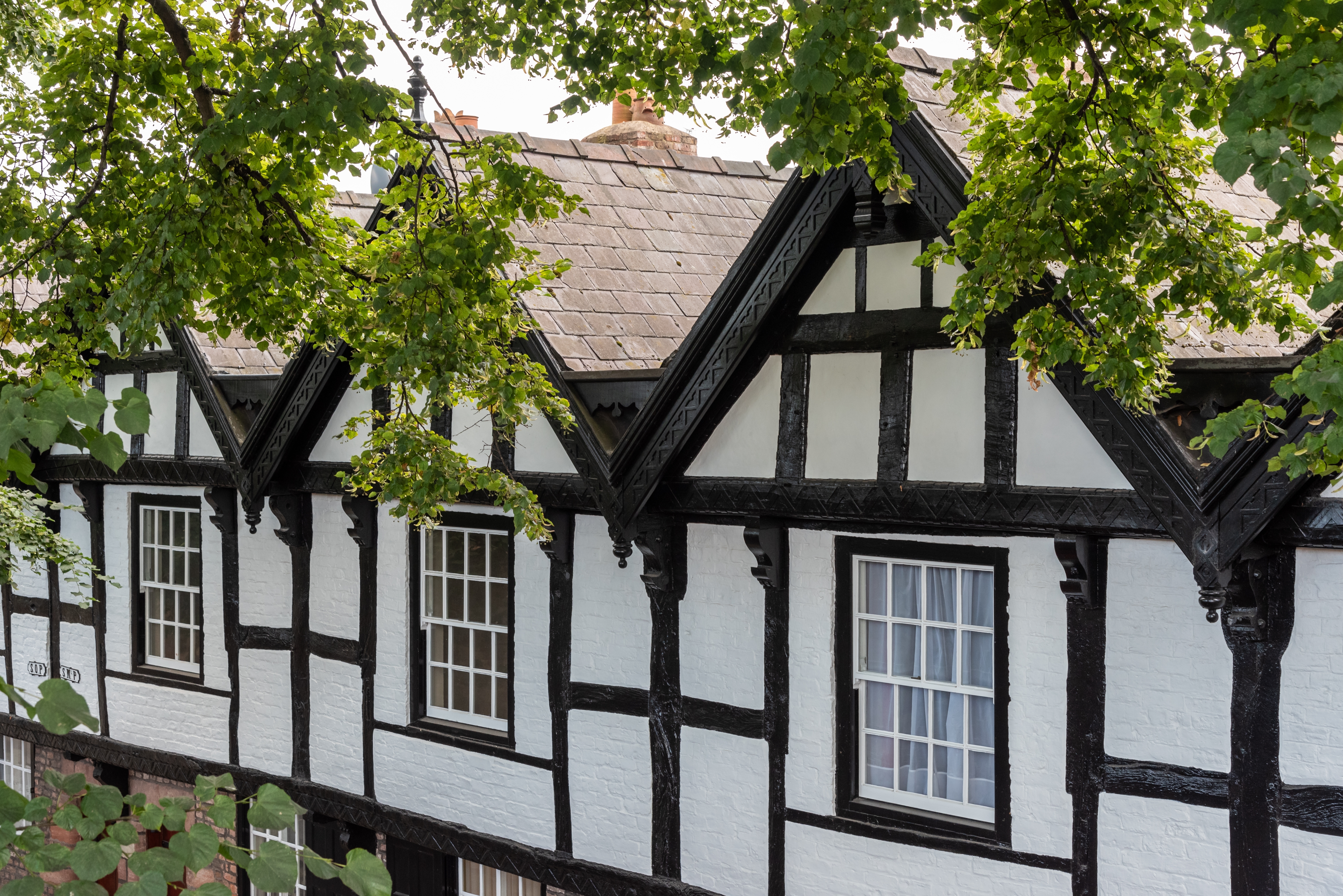 Charmerende halvtømmer-bygninger i Tudor-stil i den muromkransede by Chester i Cheshire, England