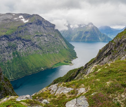 Betagende udsigt over Hjørundfjorden fra Urke vandrestien i Møre og Romsdal med stejle fjeldvægge og blåt fjordvand