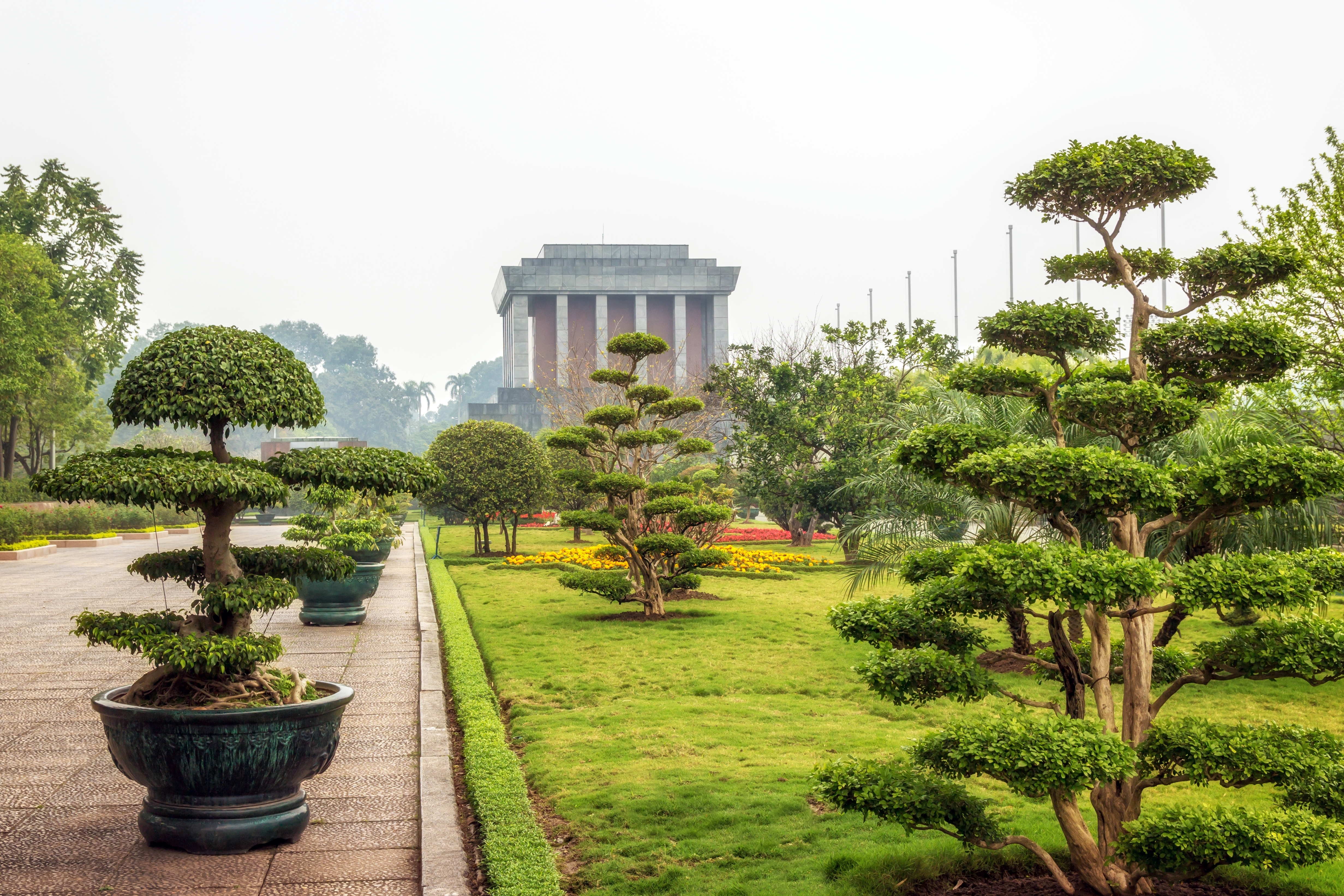 Ho Chi Minh Mausoleum i Hanoi omgivet af smukt formklippede bonsaitræer og grønne haver på Ba Dinh Pladsen i Vietnam