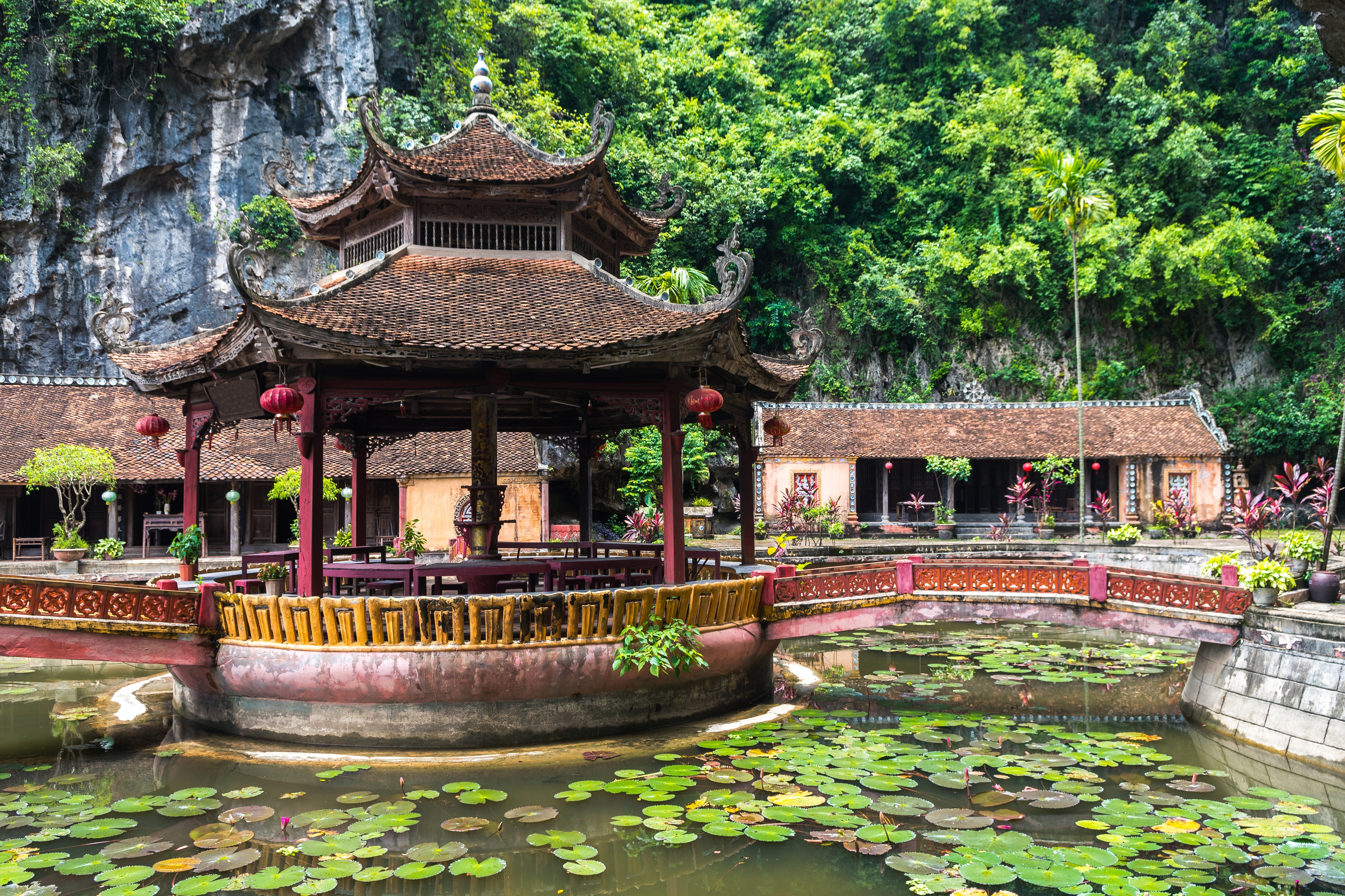 Traditionel vietnamesisk pagode med buede tage spejlet i en lotusdam ved Hoa Lu i Ninh Binh, Vietnam