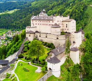 Luftfoto af det middelalderlige Hohenwerfen Slot på en klippetop med udsigt over Werfen by i Salzach-dalen, omgivet af de østrigske alper