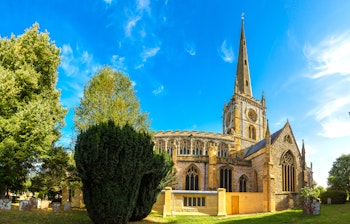 Den historiske Holy Trinity kirke i Stratford-upon-Avon med sit karakteristiske spir på en solrig sommerdag, kendt som William Shakespeares sidste hvilested