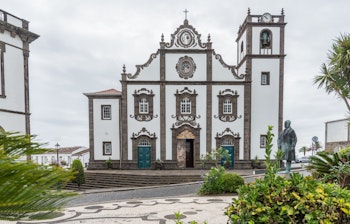 Hovedkirken i Nordeste på Sao Miguel i Azorerne, omgivet af grønne omgivelser under en skyet himmel