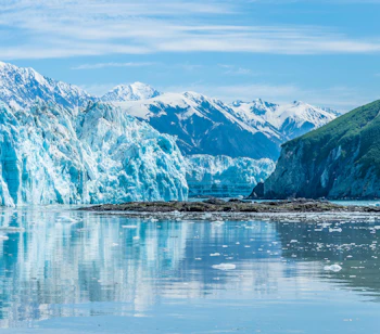 Majestætisk udsigt over Hubbard Gletsjer og Russell Fjord i Alaska med turkisblåt is og sneklædte bjerge spejlet i det rolige vand