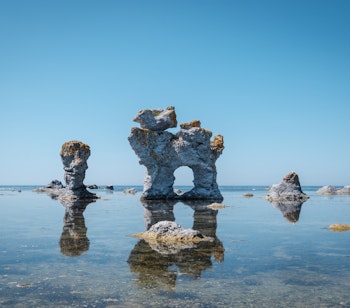 Naturlig hundeformet stenformation ved kysten på Fårö, Gotland i Sverige med blåt vand og klar himmel