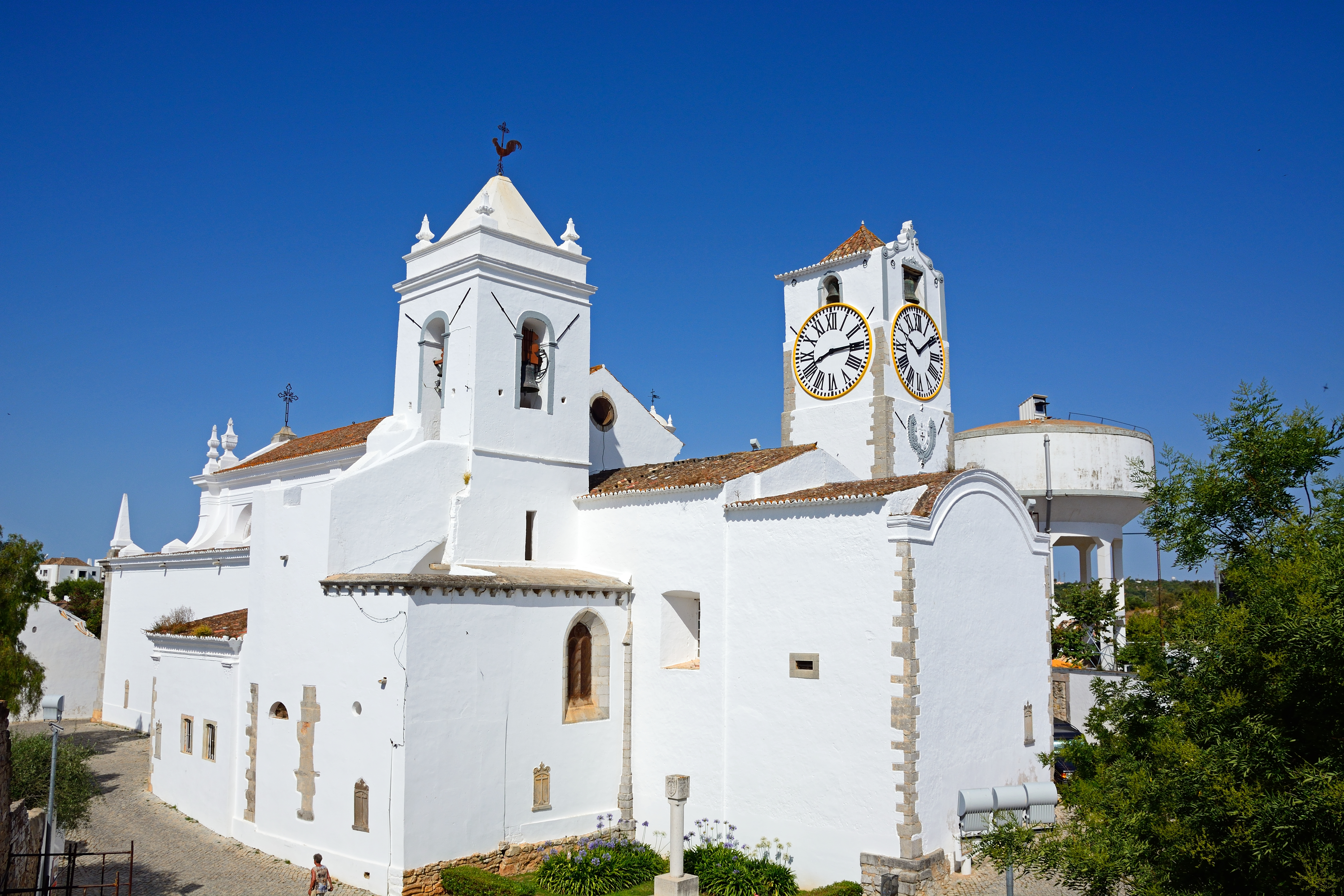 Hvid kirke med klokketårn og klokketårn i Tavira Portugal under blå himmel