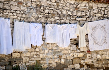 Traditionelt hvidt linned hænger til tørre i den historiske UNESCO-by Berat i Albanien med charmerende arkitektur
