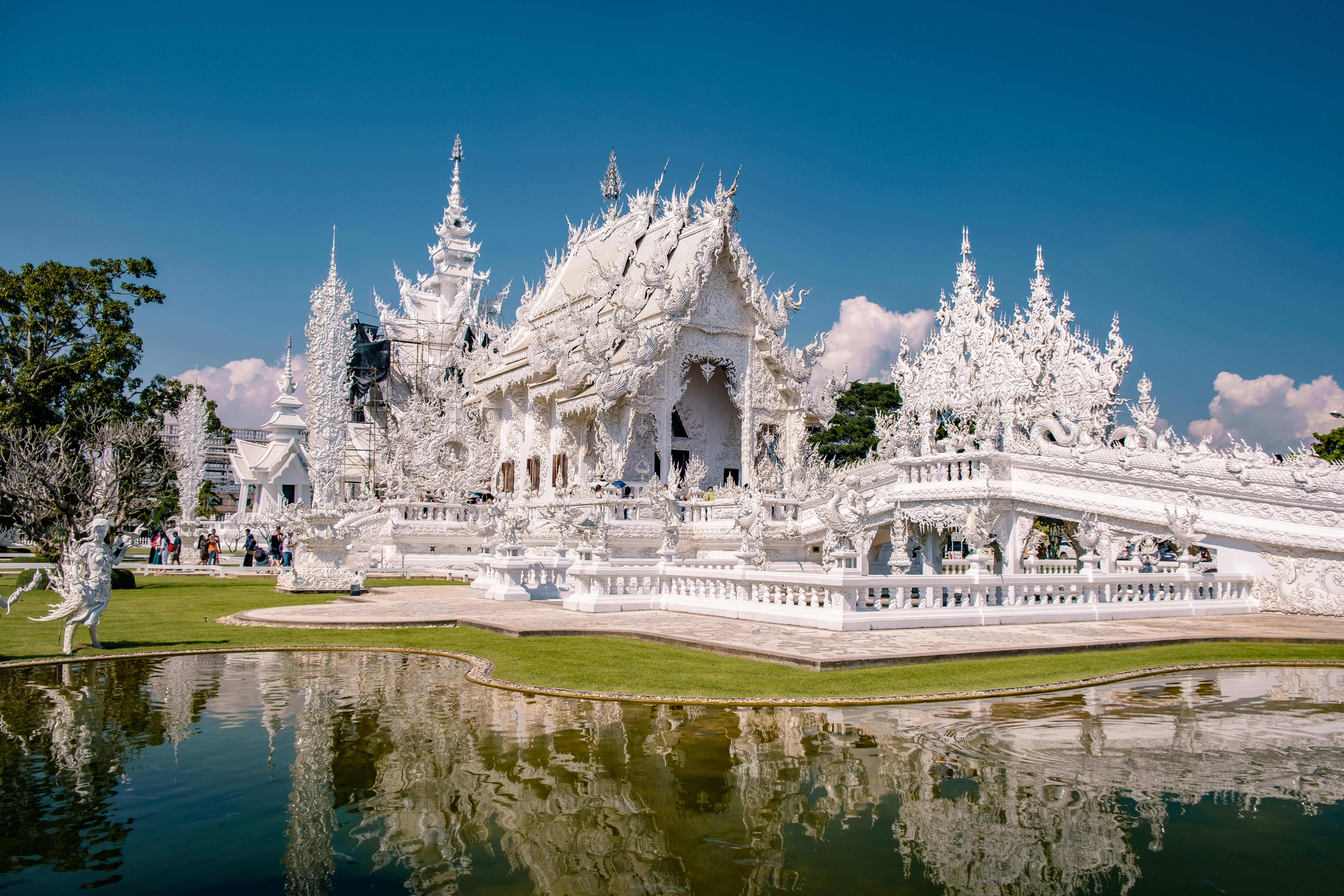 Det hvide tempel Wat Rong Khun i Chiang Rai Thailand med spejling i dam