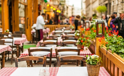 Hyggelig udendørs restaurant med ternede duge på en charmerende gade i Budapest, Ungarn
