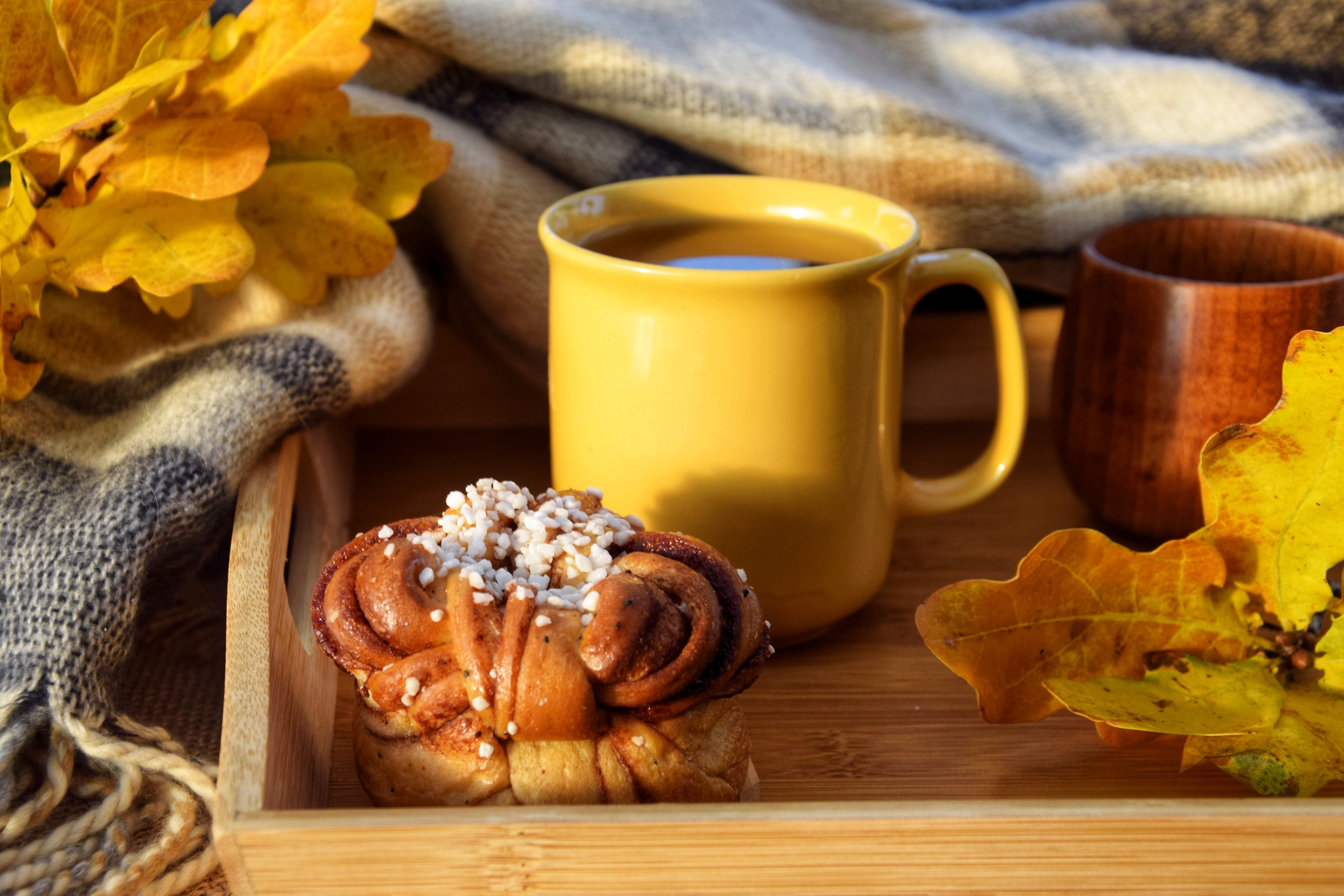 Hyggelig efterårsmorgen med kaffe og kanelbolle på træbakke