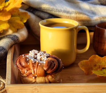 Hyggelig efterårsmorgen med kaffe og kanelbolle på træbakke