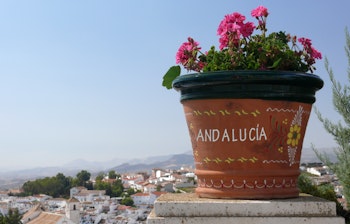 Idyllisk udsigt over den hvide landsby Colmenar i Andalusien med traditionelle blomsterkrukker og charmerende arkitektur