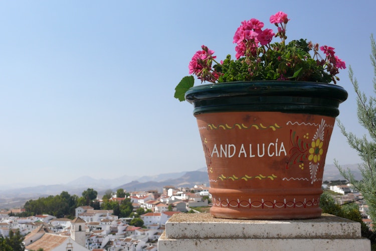 Idyllisk udsigt over den hvide landsby Colmenar i Andalusien med traditionelle blomsterkrukker og charmerende arkitektur