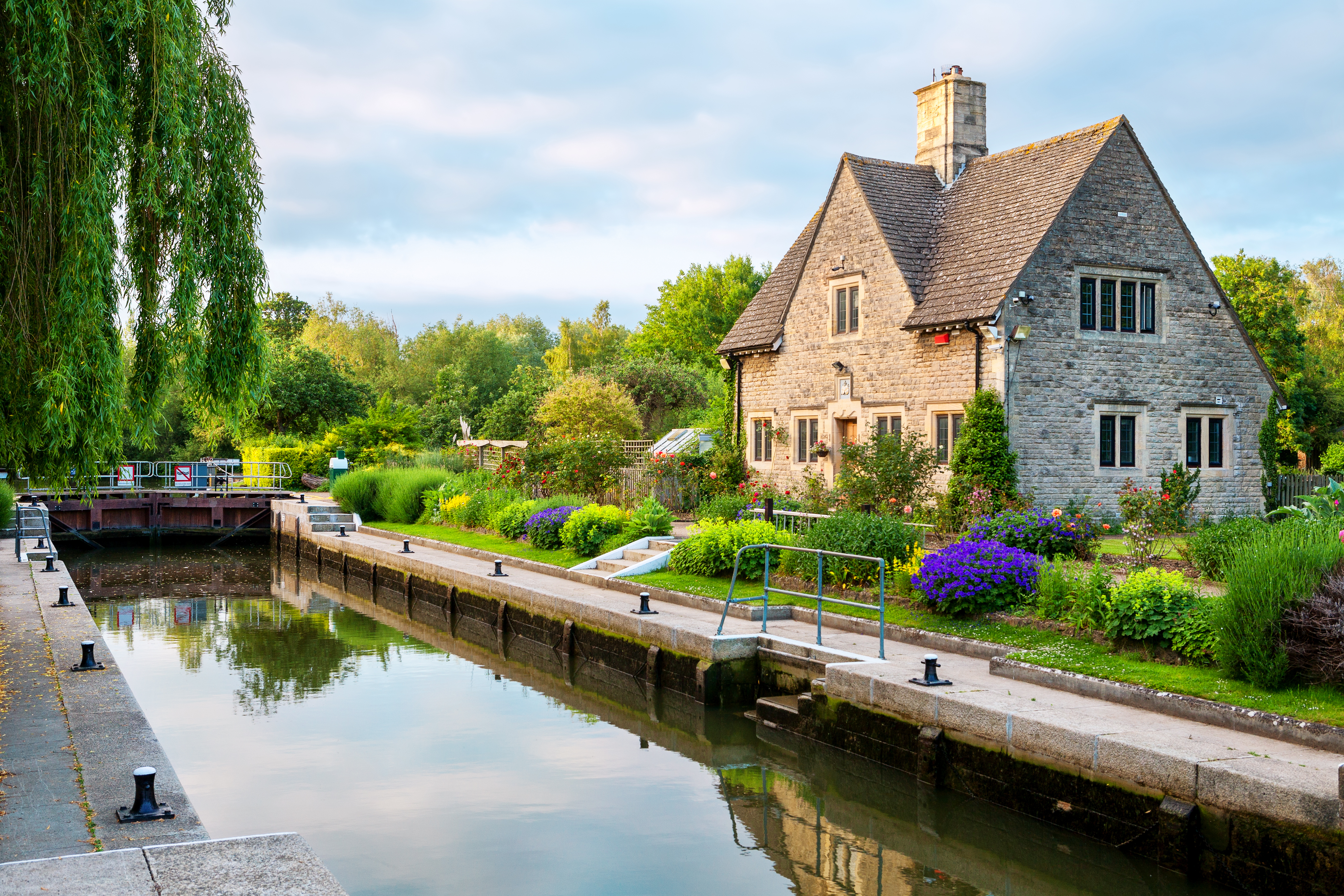 Idyllisk stenhus med farverig have ved Iffley Lock på Themsen i Oxford, England