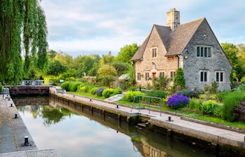Idyllisk stenhus med farverig have ved Iffley Lock på Themsen i Oxford, England