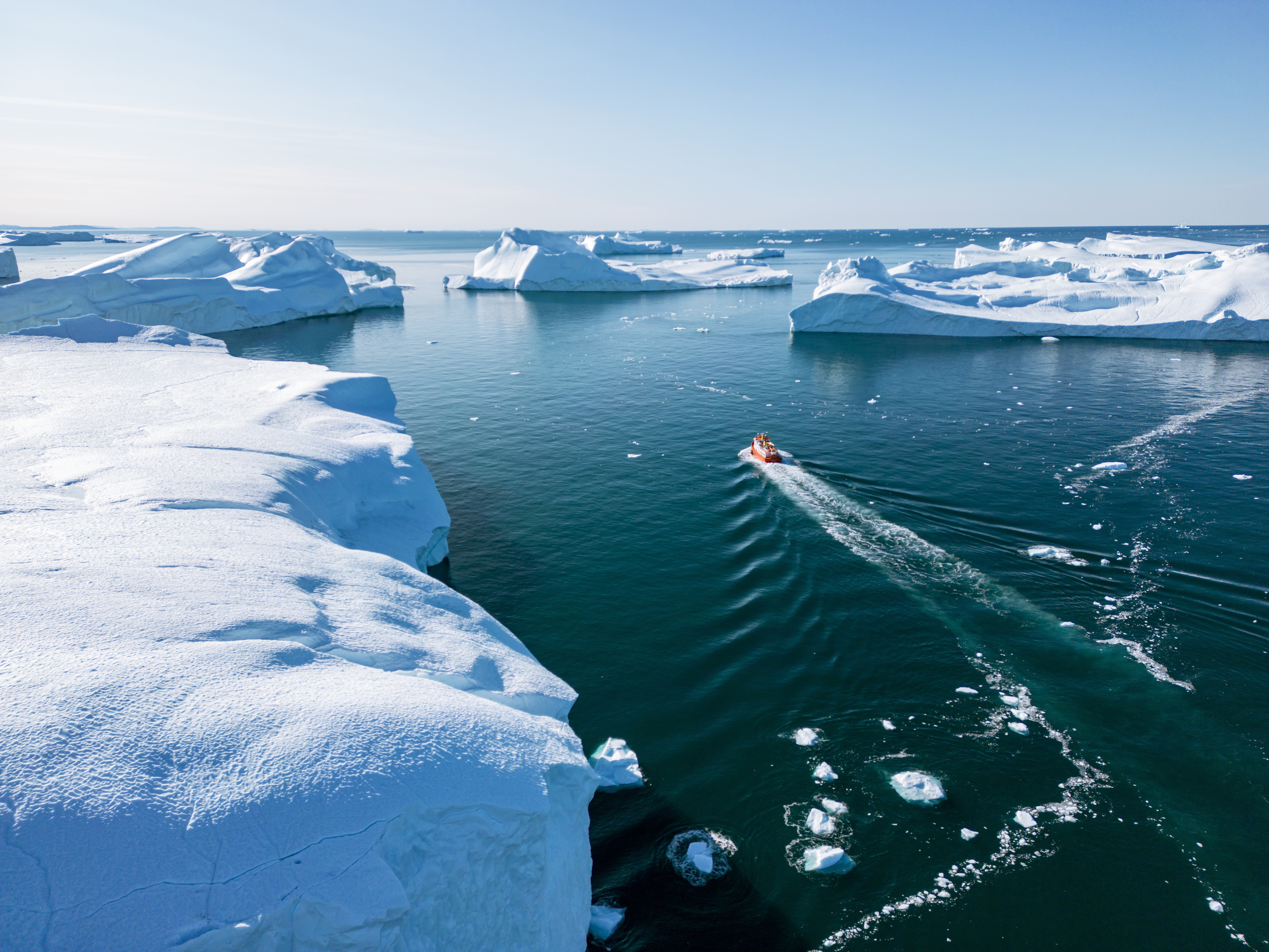 Betagende luftfoto af de majestætiske isbjerge i Ilulissat Isfjord i Grønland, hvor den aktive gletsjer møder Diskobugten - oplev et af verdens mest spektakulære arktiske naturscenerier