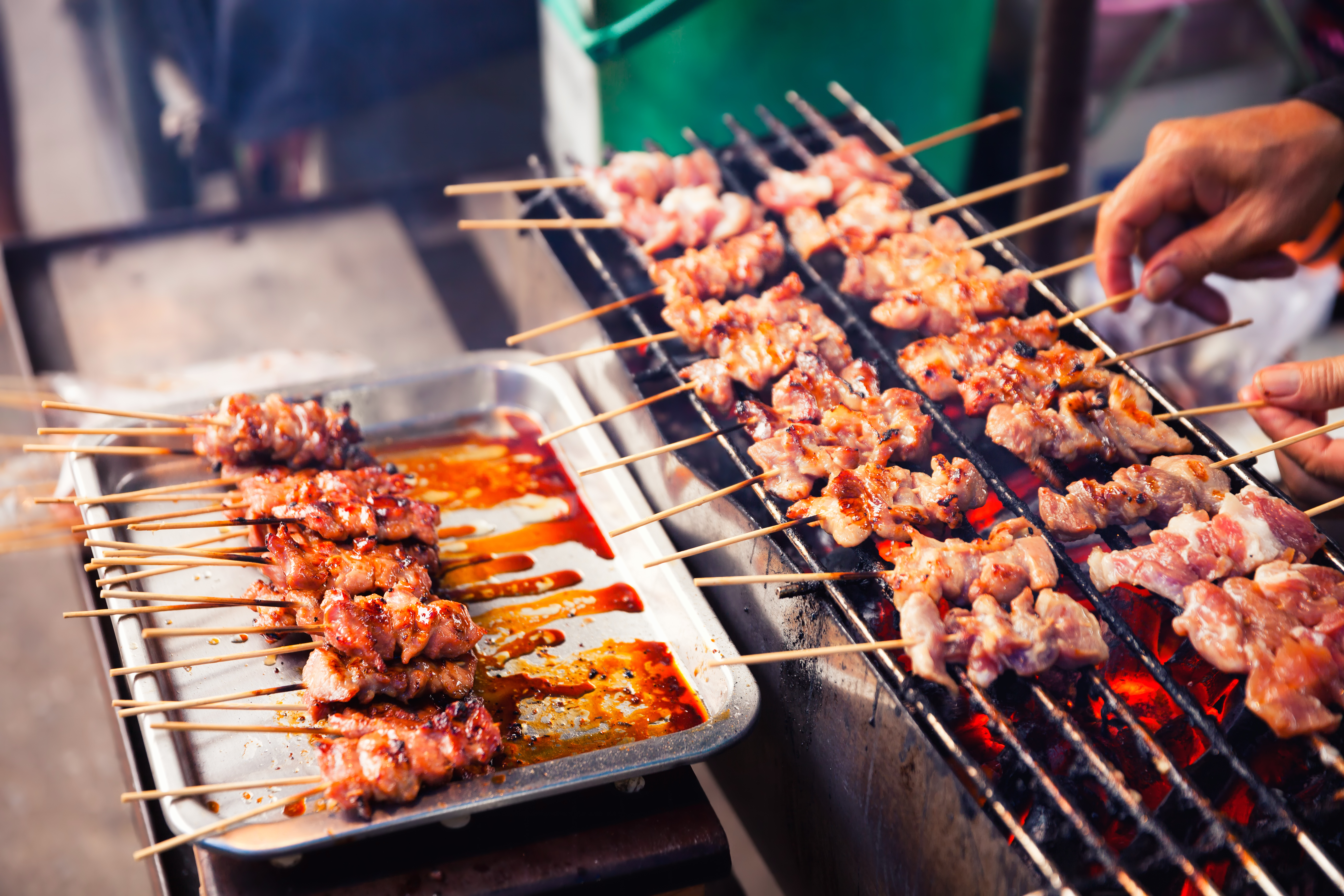 Traditionelle indonesiske satay grillspyd tilberedes på grill med krydret sauce