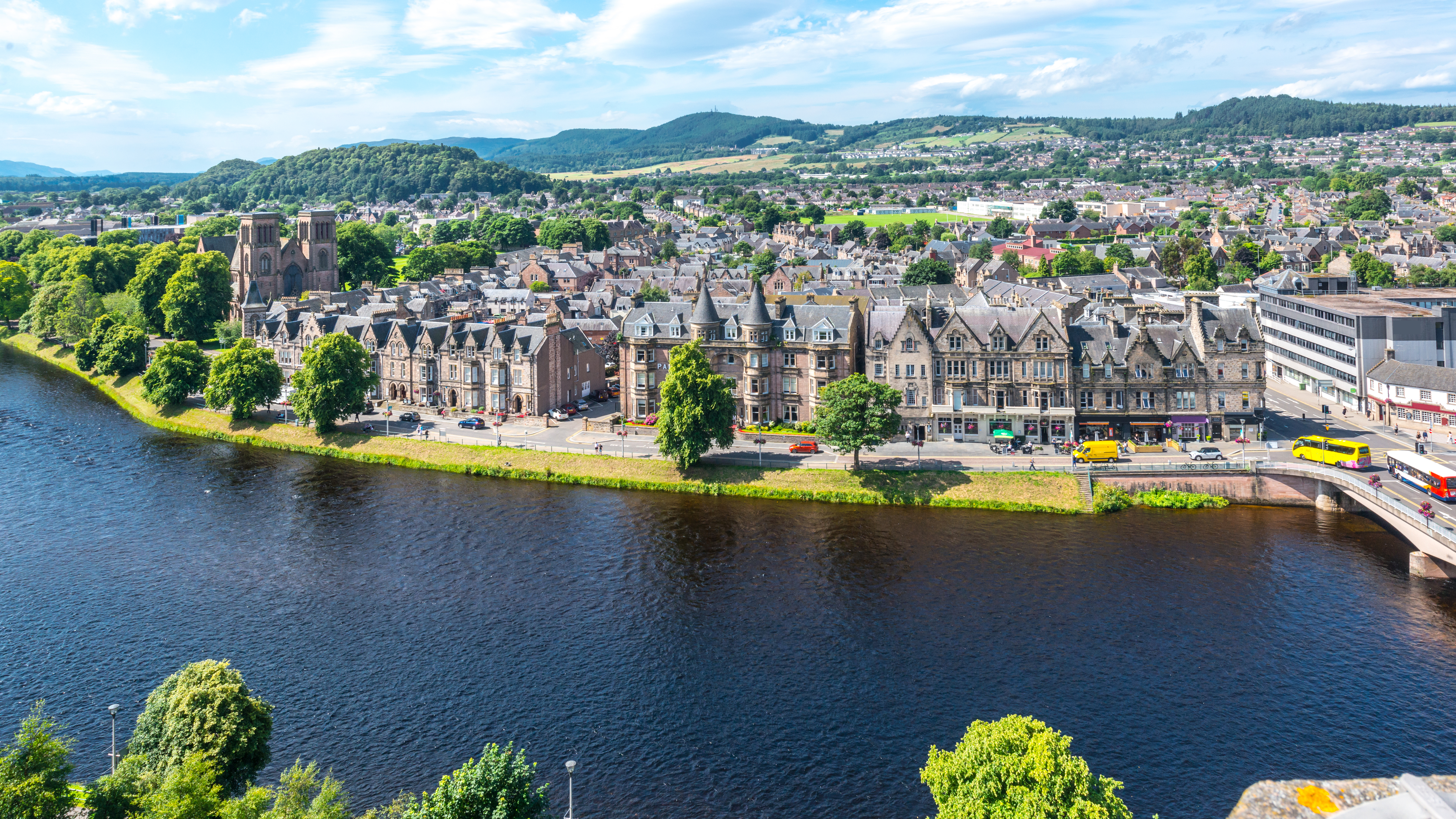 Panoramaudsigt over Inverness by langs floden Ness med historiske bygninger og skotske bjerge