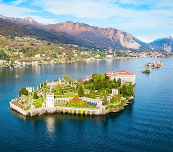 Betagende luftpanorama af Isola Bella og Stresa by ved Lago Maggiore i Norditalien med det historiske Borromeo-palads og frodige haver omgivet af azurblåt alpevand