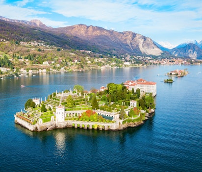 Betagende luftpanorama af Isola Bella og Stresa by ved Lago Maggiore i Norditalien med det historiske Borromeo-palads og frodige haver omgivet af azurblåt alpevand