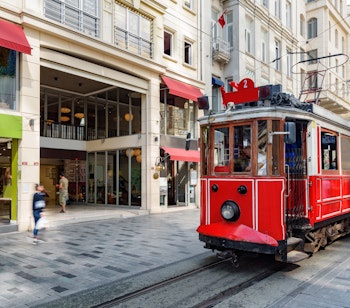 Den ikoniske røde nostalgiske sporvogn på Istiklal Avenue i Istanbul. En populær turistattraktion i Tyrkiets største by på en solrig dag.
