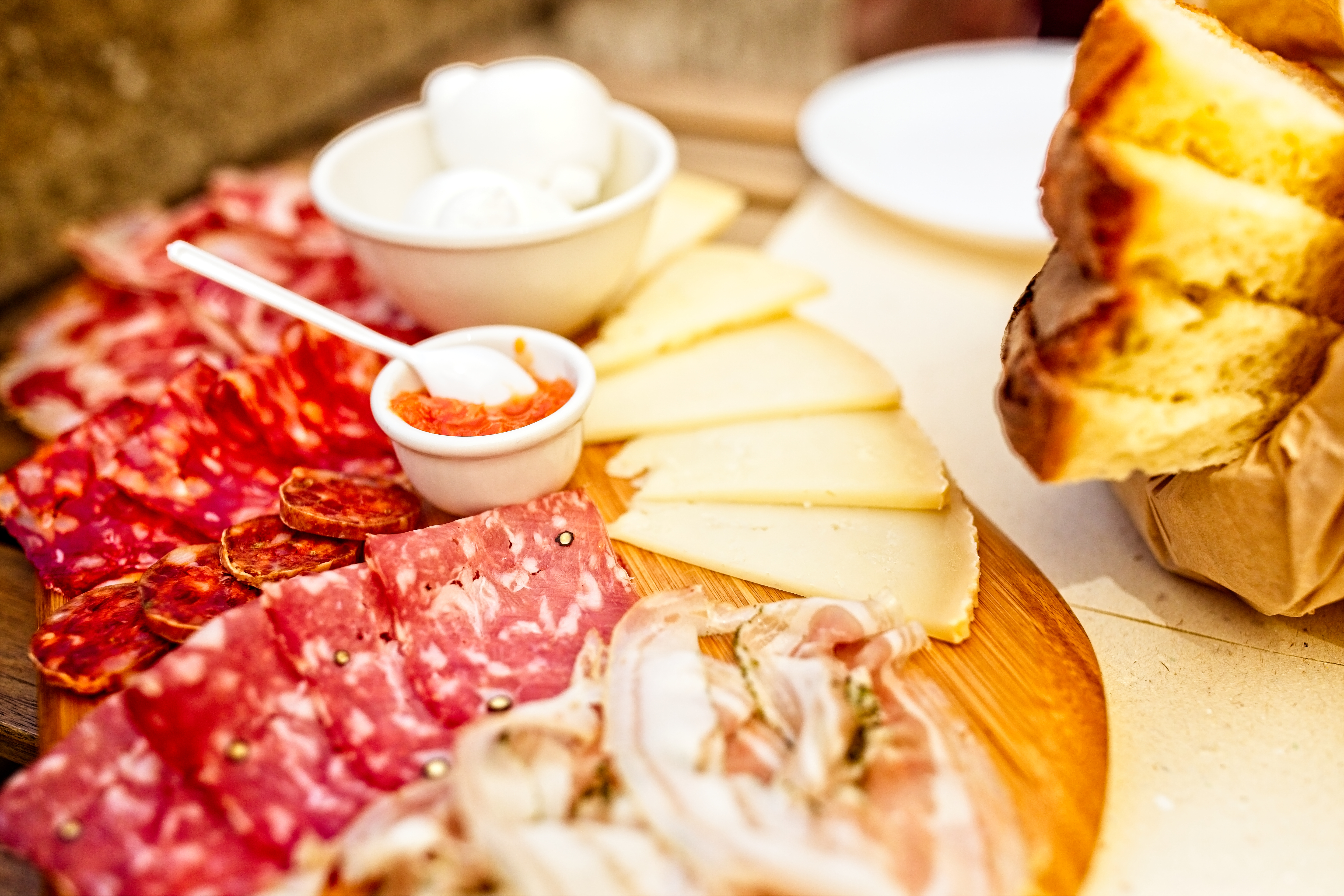 Traditionel italiensk antipasti tallerken med spegepølse, ost og friskt brød på restaurant