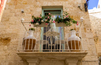 Traditionel italiensk balkong med blomster i historisk Puglia Italien