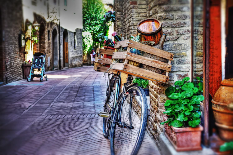 Traditionel italiensk cykel med trækasser på brolagt gade i Toscana