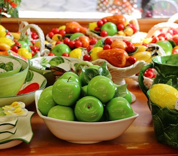 Farverige italienske keramikfade med håndmalede frugtmotiver, typisk kunsthåndværk fra Gardasøen-regionen