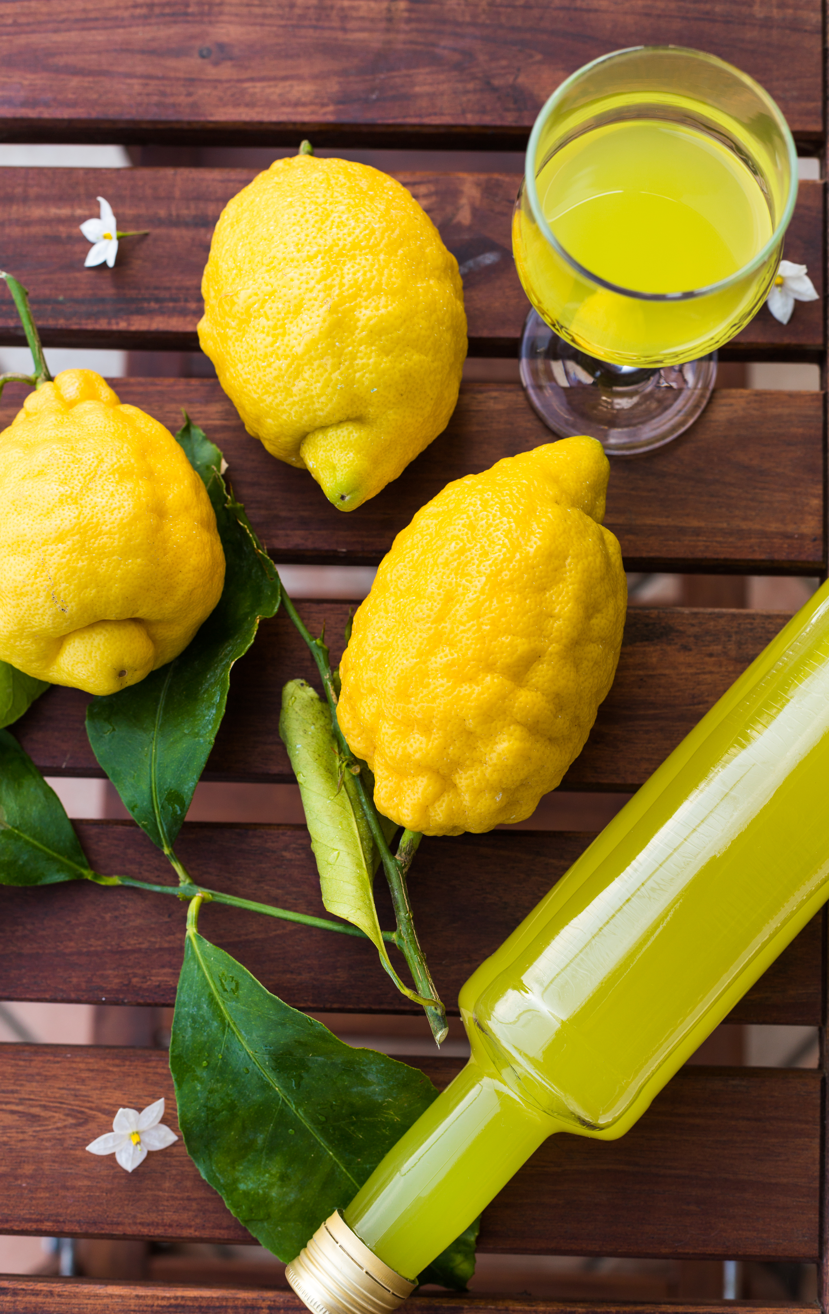 Traditionel italiensk limoncello med friske citroner serveret på terrasse i Amalfi - en forfriskende smagsoplevelse på din rejse til Italien